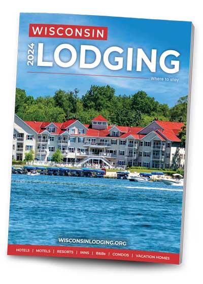 Cover image of the 2024 Wisconsin Lodging Directory. Photo of exterior of Delavan Lake Resort (Delavan, WI) taken from out on the water.